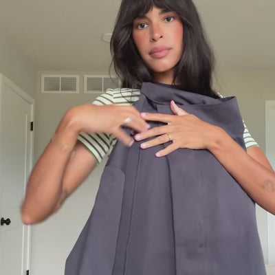 Video einer Frau, die die BulgariaLL Jacke von Lollys Laundry in einem gedeckten Lilaton mit Oversize-Passform, Knöpfen und weiten Ärmeln präsentiert, kombiniert mit gestreiftem Oberteil und Jeans.
